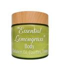A jar of 'Essential Lemongrass' Body Balances Oil, Clairifies, and Tones, featuring a light wood-grain lid and a translucent olive-green glass jar with white text.