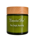 A green glass jar of 'Essential Face' skincare cream with a light wood-grain lid, set against a plain white background.