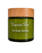A green glass jar of 'Essential Face' skincare cream with a light wood-grain lid, set against a plain white background.